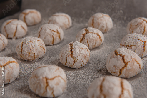 Amaretti - traditional italian almond cookies in sugar powder on baking paper.