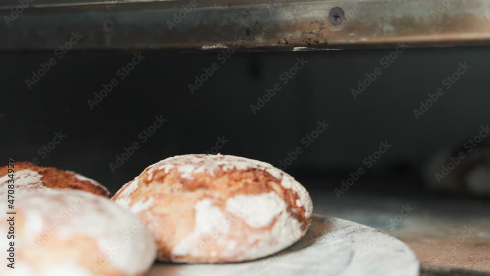 Fresh bread in the oven, being taken out.