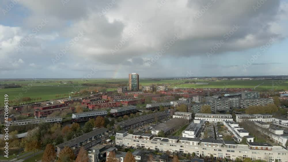 High Jib up over a beautiful city with dark clouds and a rainbow in the background High Jib up over a beautiful city with dark clouds and a rainbow in the background