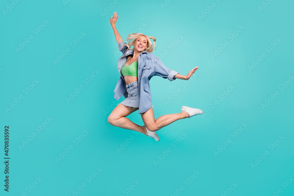 Full length photo of happy crazy happy cheerful woman wind blow summer jump up isolated on blue color background