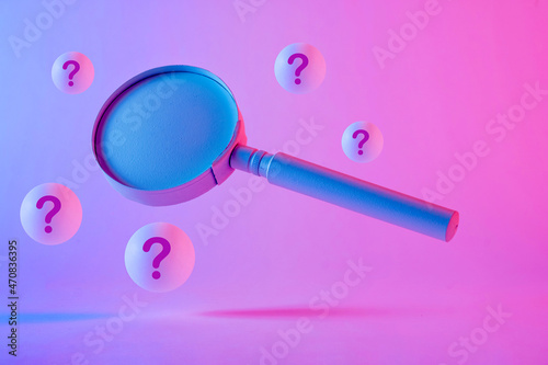 Foto Close-up of a magnifying glass floating between question marks