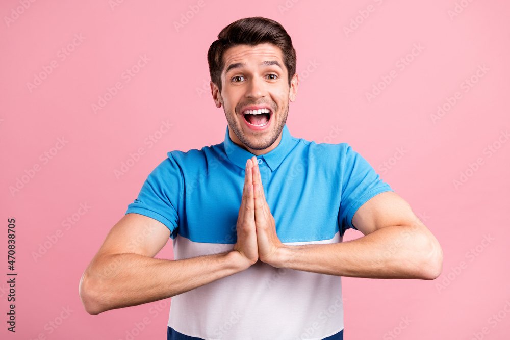 Photo of funny brunet millennial guy hold hands wear blue t-shirt isolated on pink color background