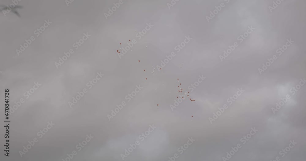 red and white balloons flying in a cloudy sky red and white balloons flying in a cloudy sky