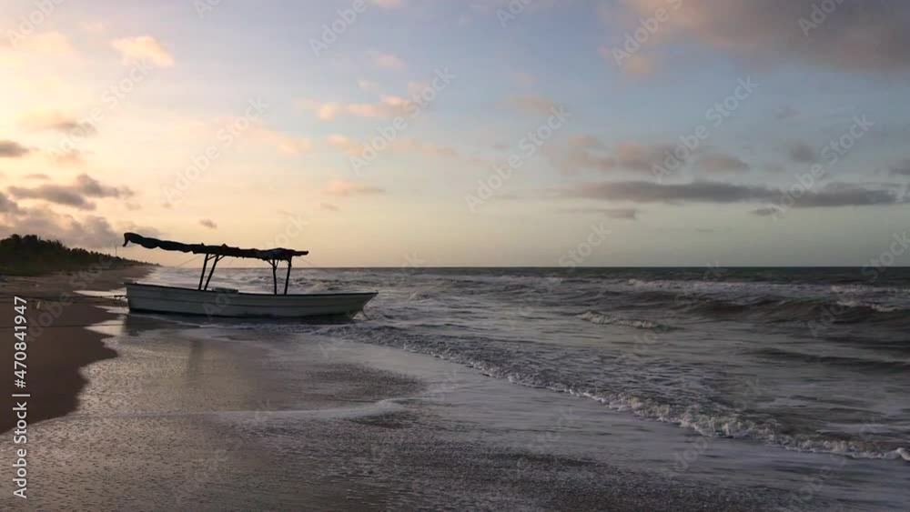 Small fishing boat on a sandy Caribbean Sea beach during sunset Small fishing boat on a sandy Caribbean Sea beach during sunset