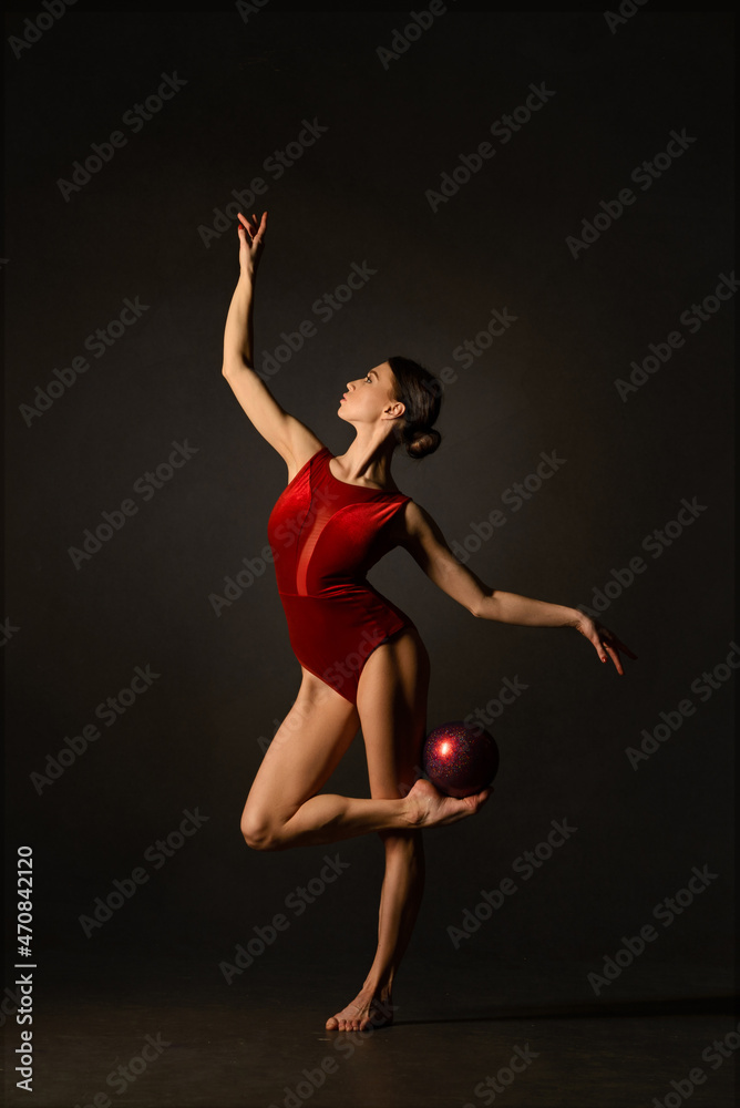 Gymnast with red ribbon on gray background