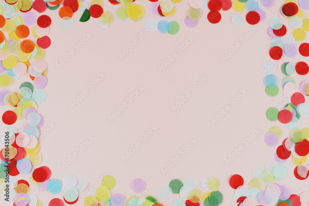 Confetti multicolor on a pink background. Top view, copy space