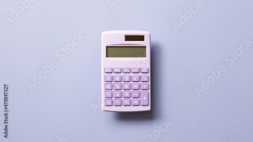 Purple digital calculator isolated on purple background. top view, copy space photo