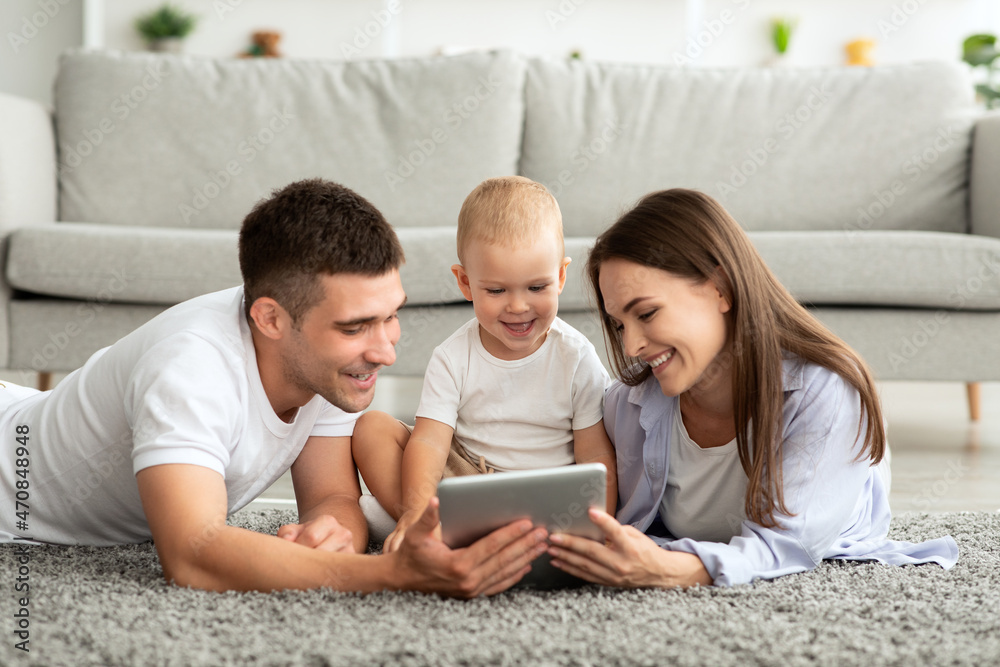 Cheerful Young Parents And Toddler Baby Relaxing With Digital Tablet At Home Cheerful Young Parents And Toddler Baby Relaxing With Digital Tablet At Home
