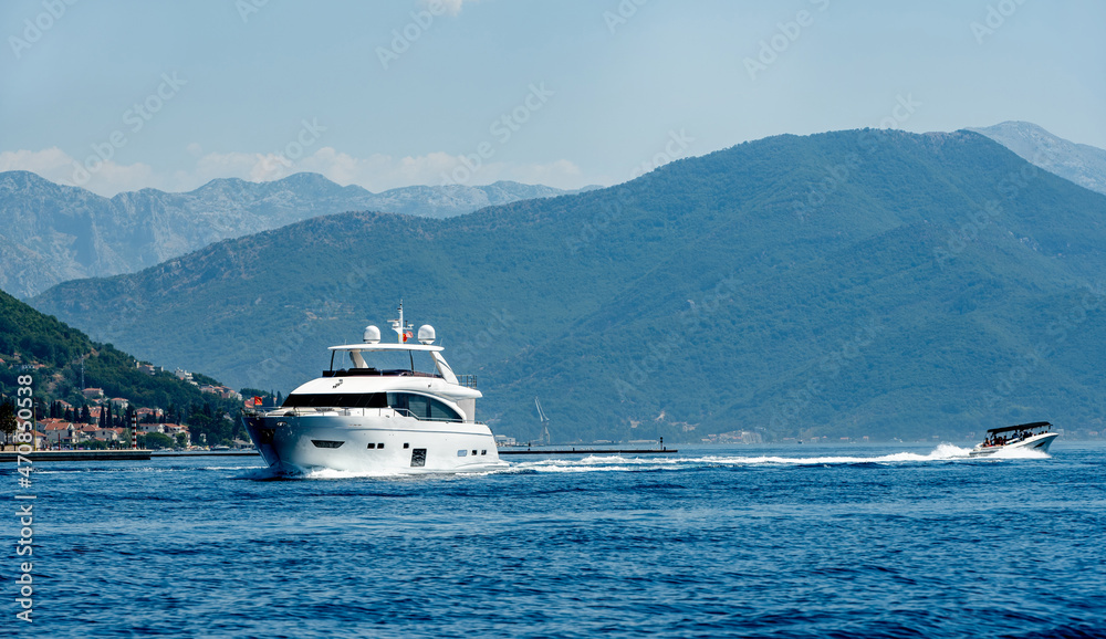 Luxury boat yacht in Adriatic sea in Montenegro with scenic mountains view. Amazing landscapes of balkans and sailing transport