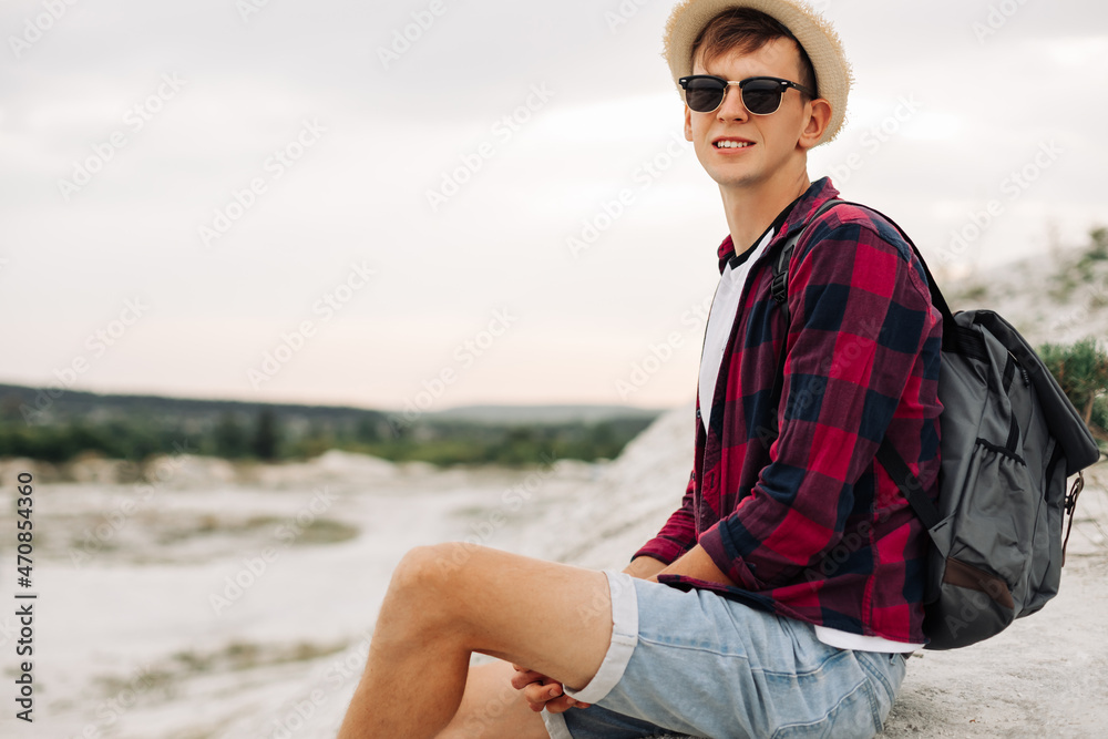 man sits on the top of the mountain and enjoys the amazing view of the mountains.