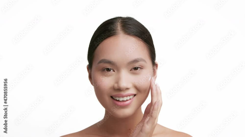 Korean Millennial Lady Applying Moisturizer Cream On Face, White Background Korean Millennial Lady Applying Moisturizer Cream On Face, White Background