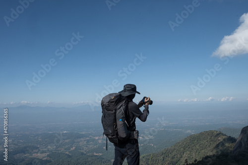 hikers traveling with backpacks taking pictures on the top of the mountain