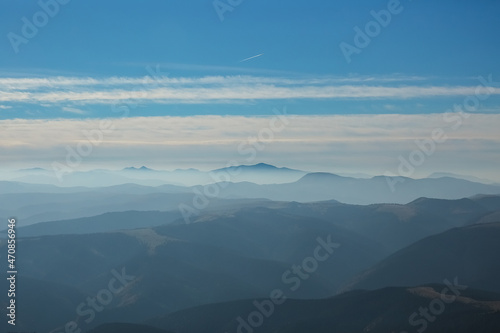 The beautiful landscape, silhouette of mountains covered with coniferous wood, cloudy blue sky after sunset