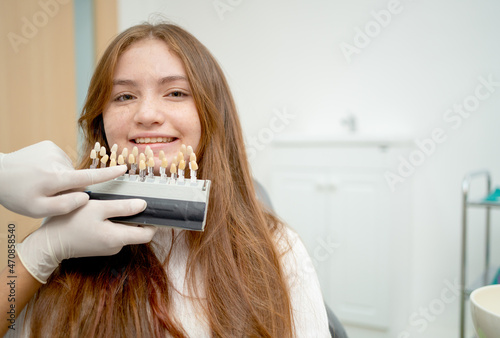 Close up face of young girl with dentist use teeth shade guide in dental clinic.