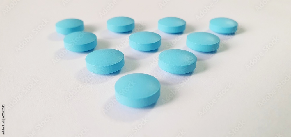 Blue tablets and vitamins without packaging on the table. Treatment pills. Useful vitamins for treatment. Blue tablets and vitamins without packaging on the table. Treatment pills. Useful vitamins for treatment.