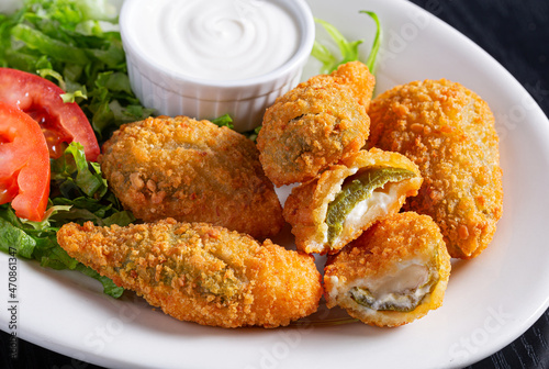 Jalapeno Poppers with sour cream in a white plate photo