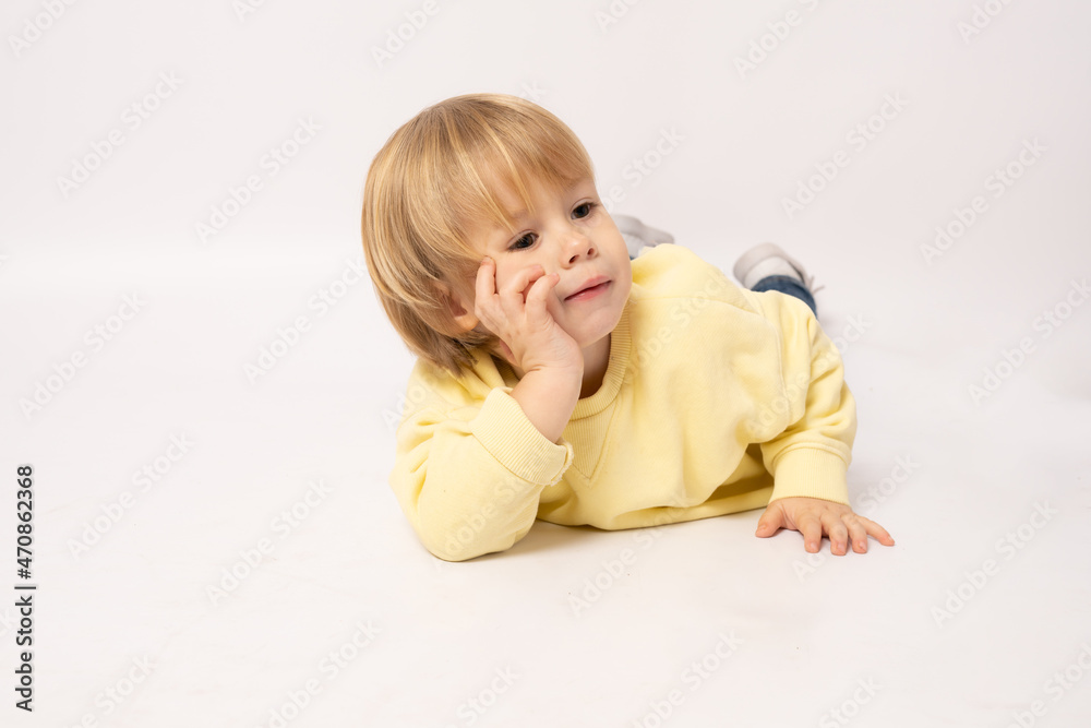 Portrait of beautiful little boy lying on floor isolated over white background. Portrait of beautiful little boy lying on floor isolated over white background.