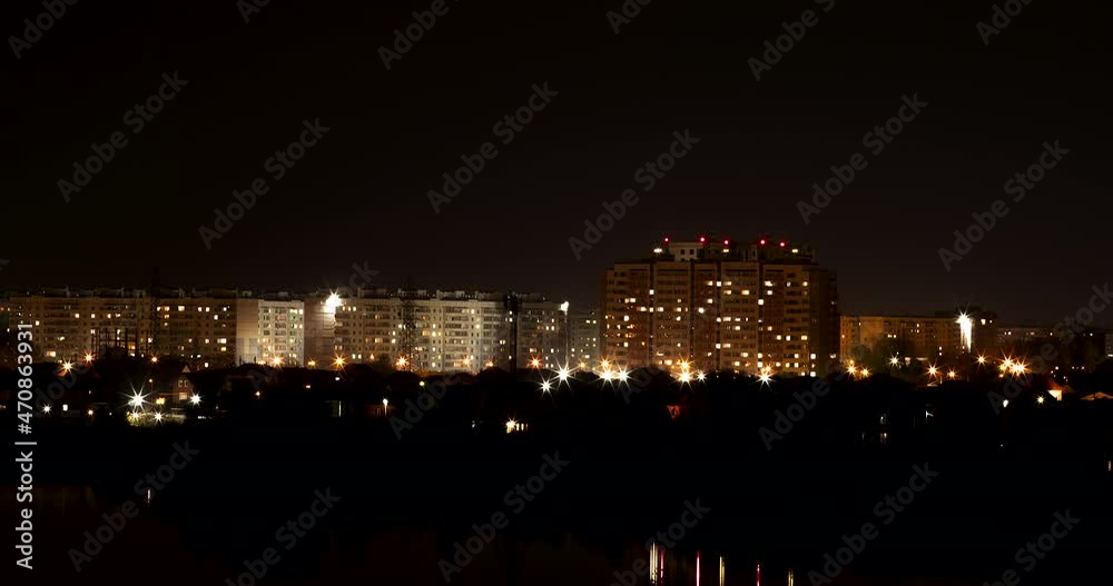 Illuminated brightly high-rise dwelling buildings in center of city under black sky without stars from evening till night time-lapse Illuminated brightly high-rise dwelling buildings in center of city under black sky without stars from evening till night time-lapse