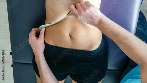 Osteopath performing diaphragm coastal release with IASTM tool photo