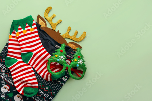 Merry Christmas. Top view of christmas sweater with christmas socks,bright Christmas toy deer antlers and funny glasses.Christmas concept background