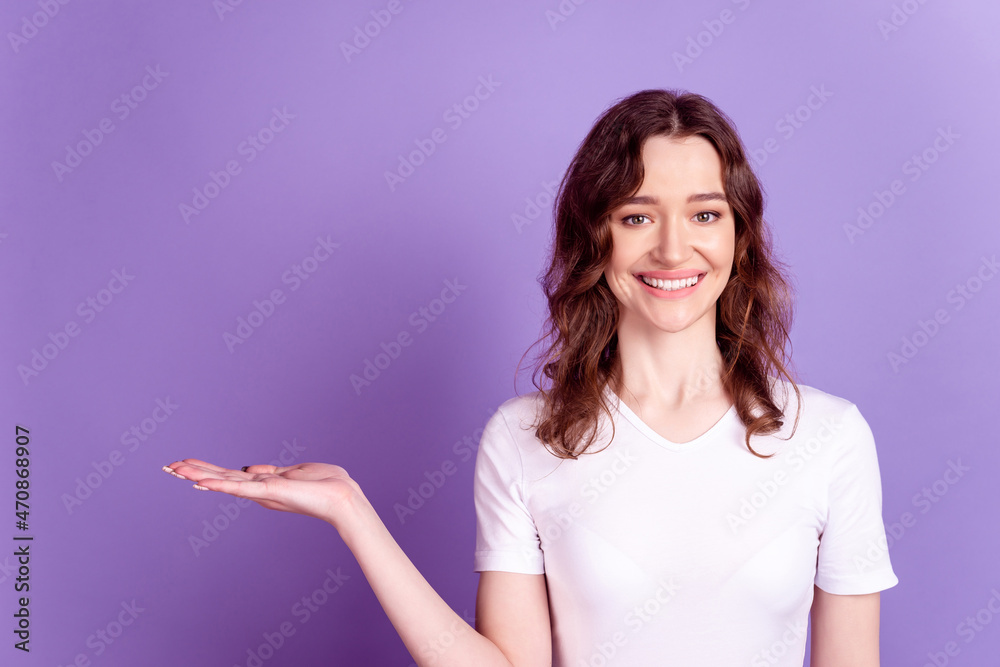 Photo of young lovely girl hold hand product promotion advertise isolated over purple color background Photo of young lovely girl hold hand product promotion advertise isolated over purple color background