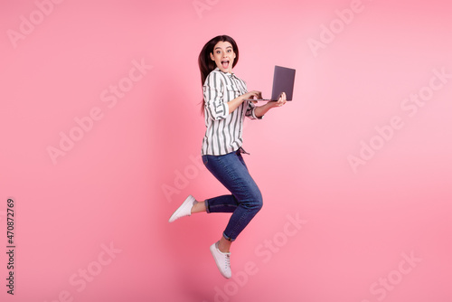 Full body profile side photo of excited girl jump use laptop agent manager isolated over pink color background
