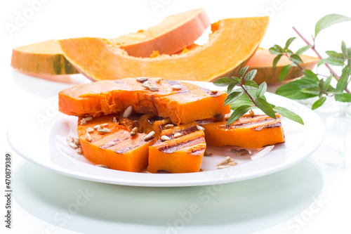sweet baked grilled pumpkin with seeds in a plate