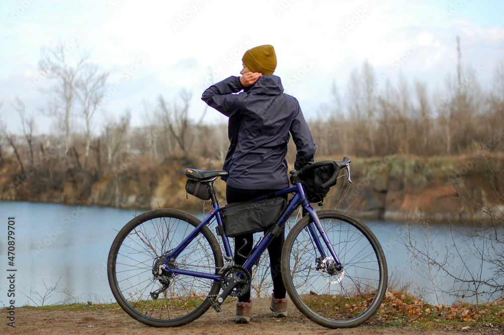 Girl with bike on the lake in autumn