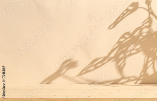 Wooden table mockup on stucco background with branch shadows on the wall. Mock up for branding products, presentation and health care. 