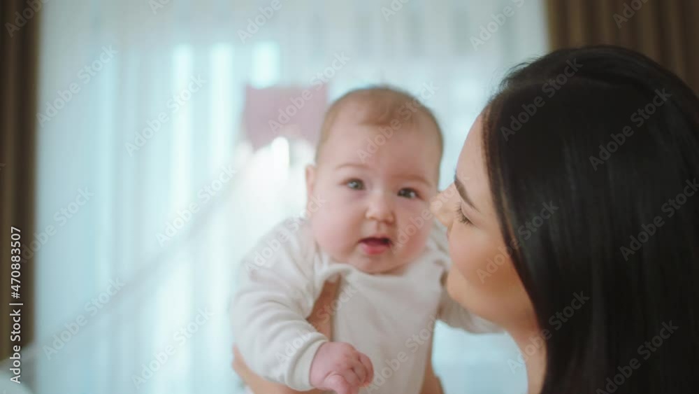 In front of the camera beautiful and charismatic woman hugging with love her baby girl and closing the eyes she enjoy the motherhood In front of the camera beautiful and charismatic woman hugging with love her baby girl and closing the eyes she enjoy the motherhood