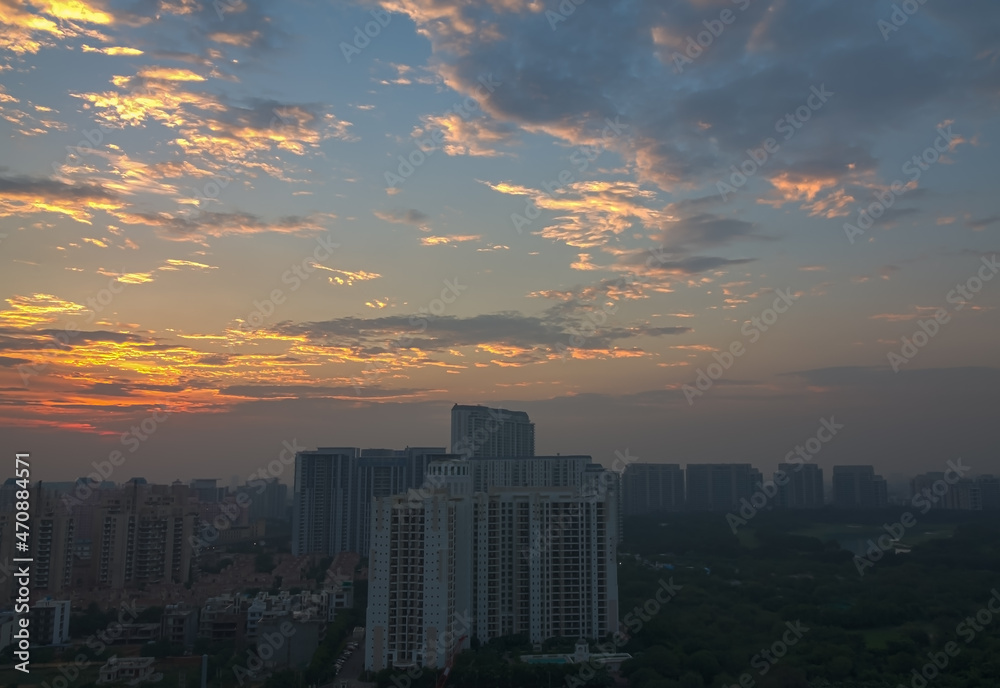Beautiful sunset,overcast sky covered with mackerel clouds in Gurugram Haryana,India.Delhi NCR’s business,residential and commercial hub.View of urban cityscape during monsoon and pandemic.