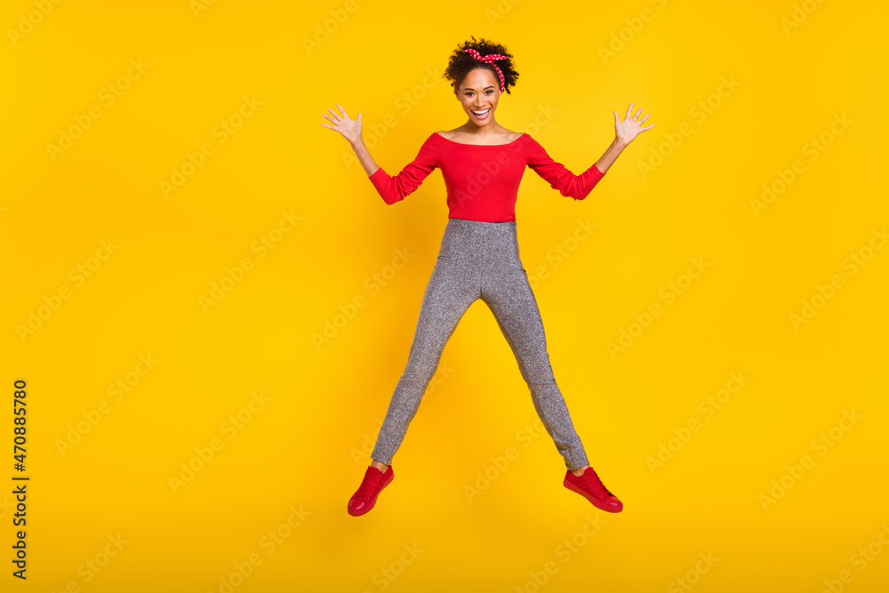 Photo of carefree crazy cute lady jump have fun raise hands wear pin-up outfit isolated yellow color background