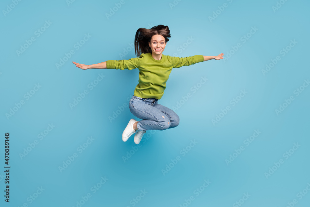 Photo of inspired pretty lady jump plane flight concept wear green shirt jeans footwear isolated blue color background