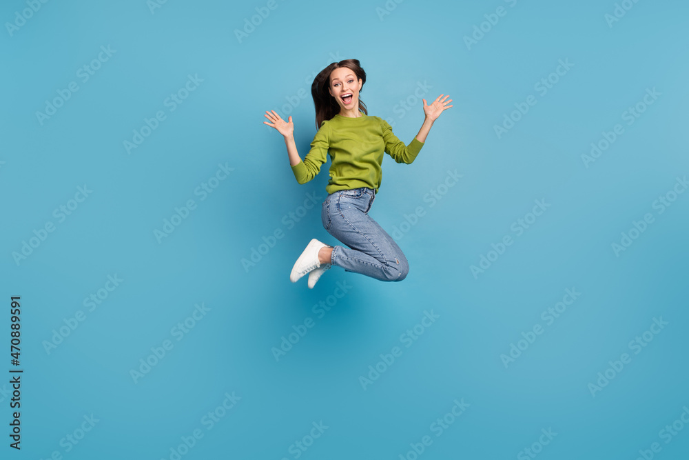 Photo of astonished positive lady open mouth wear green shirt jeans sneakers isolated blue color background