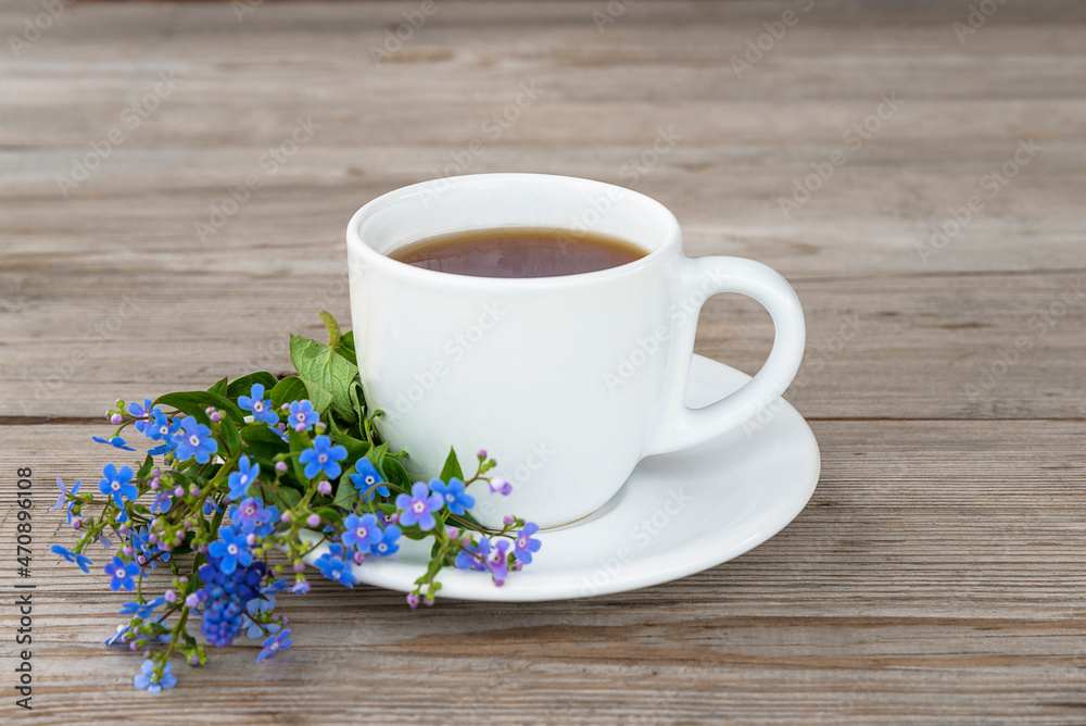 Happy mother's day greeting card; white cup of coffee or tea and bouquet of blue forget me not flowers on wooden background close up Happy mother's day greeting card; white cup of coffee or tea and bouquet of blue forget me not flowers on wooden background close up