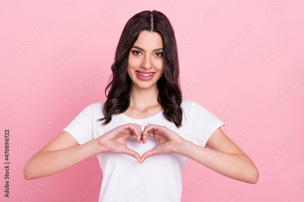 Photo of young happy charming woman make fingers heart shape smile isolated on pink color background Photo of young happy charming woman make fingers heart shape smile isolated on pink color background
