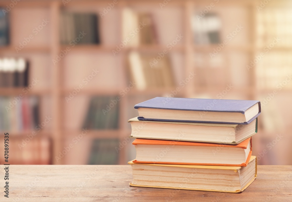 Stack of books on the table in the library background Stack of books on the table in the library background