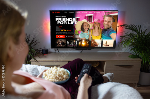 Woman watching TV series and movies on online streaming service at home photo