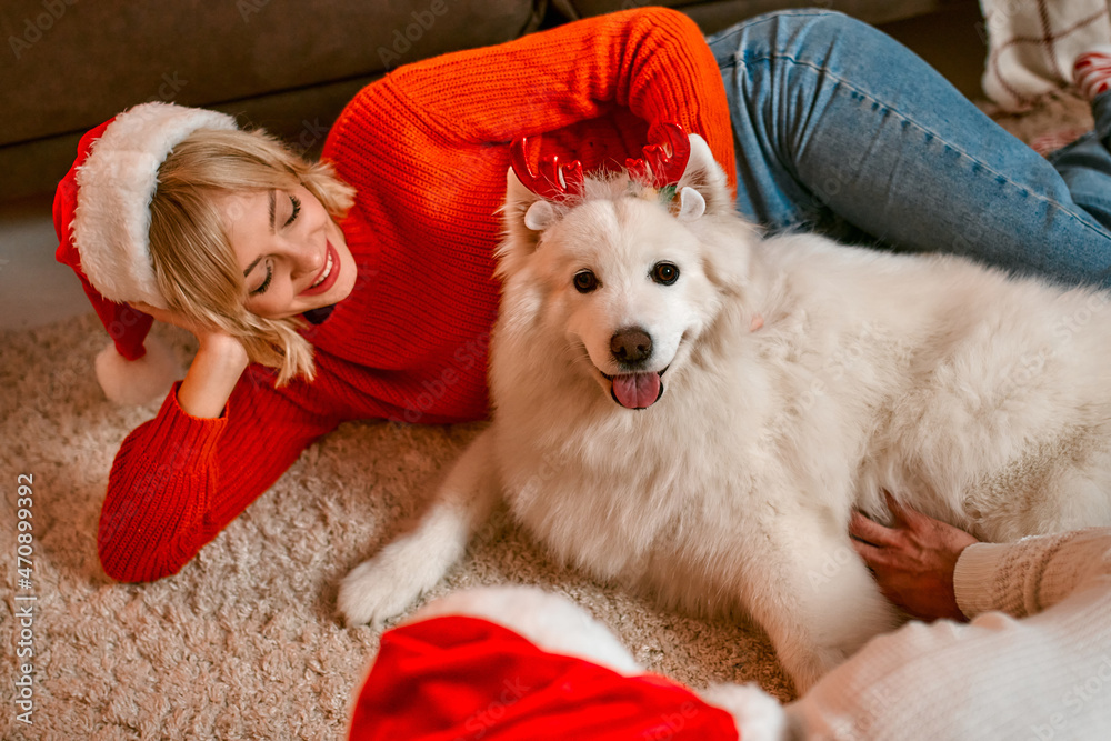 Fototapeta premium Couple in love for New Year and Christmas with a dog at home