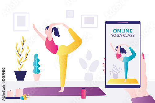 Cute woman stands in pose of king of dance. Girl practices yoga on online course. Coach on screen stands in natarajasana