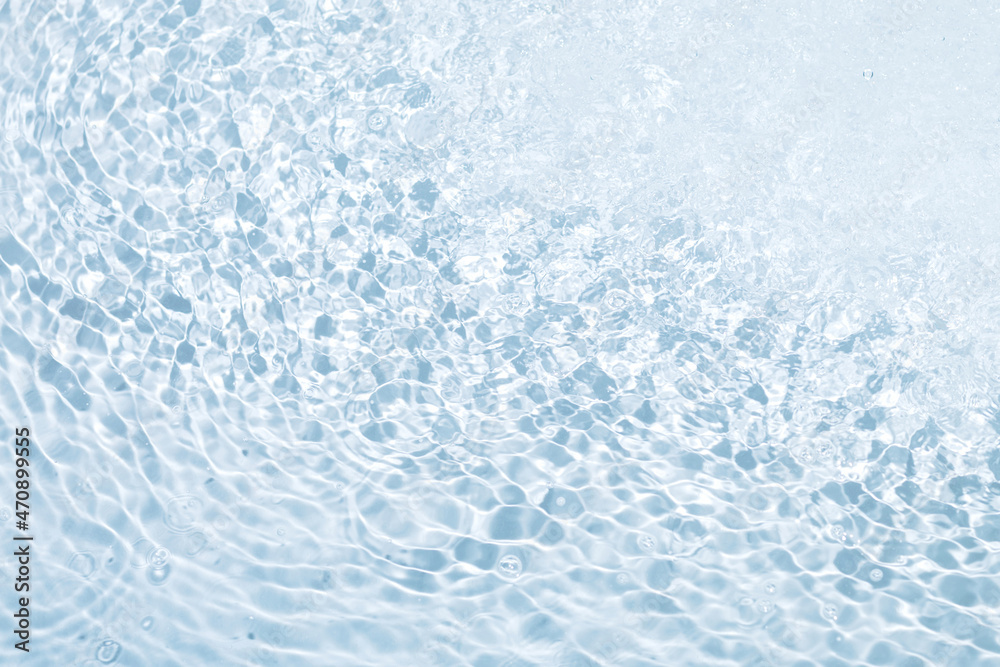 Blue seething water background with flying drops, bubbles and circles on the surface. Modern concept for perfect design