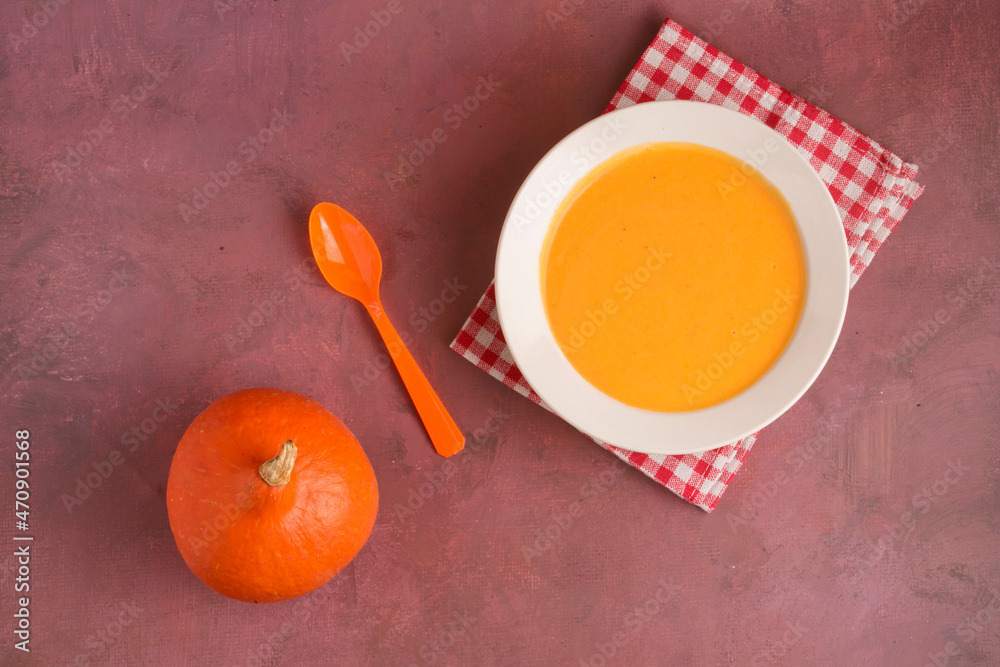 Plate with pumpkin soup on a light background Plate with pumpkin soup on a light background