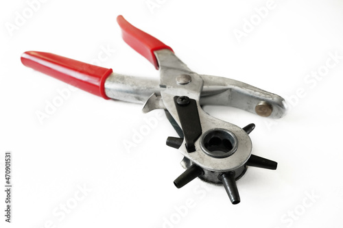 Puncture holes in the strap using a punch isolated on white background. Belt Hole Puncher Power Assist Heavy Duty Revolving Eyelet Punch Plier