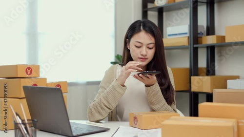 Wallpaper Mural Young asian business woman writing address to sending product to customer using smartphone scan qr code on the box. Online business working at home. Startup Small business owner entrepreneur  Torontodigital.ca