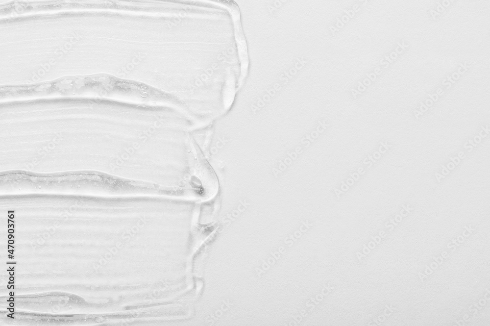 Clear emulsion cosmetic product for body skin moisturizing strokes and space for design on white surface close view from above Clear emulsion cosmetic product for body skin moisturizing strokes and space for design on white surface close view from above