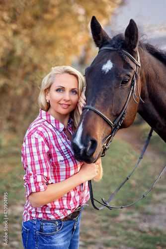 beautiful caucasian girl with a horse in the forest at sunset