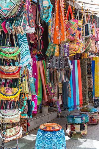 Selling clothes, fabrics and gifts at local street market in holy city Pushkar, Rajasthan, India