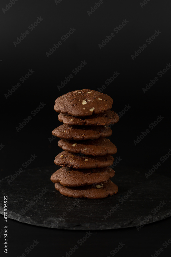 chocolate chip cookies are stacked on a black mantelpiece on a black background chocolate chip cookies are stacked on a black mantelpiece on a black background