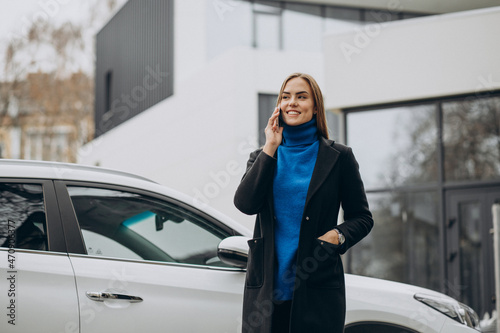 Woman standing by her car outside the street