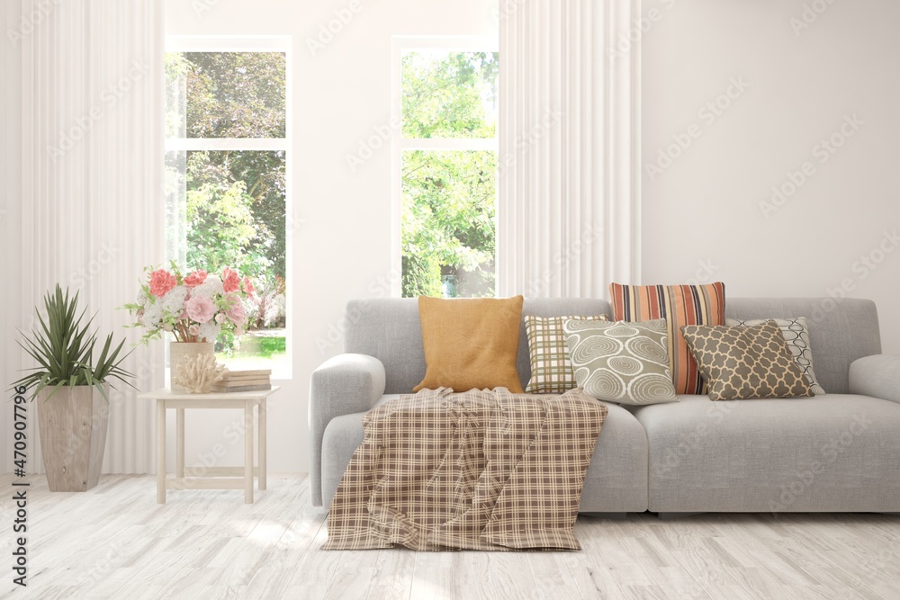 Fototapeta premium White living room with sofa and summer landscape in window. Scandinavian interior design. 3D illustration
